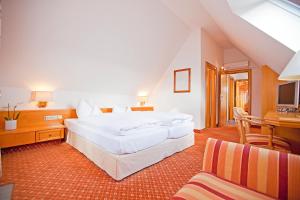 ein Schlafzimmer mit zwei weißen Betten und einem Schreibtisch in der Unterkunft Hotel Krone OHG in Gerlingen
