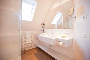ein weißes Badezimmer mit Waschbecken und Spiegel in der Unterkunft Hotel Krone OHG in Gerlingen