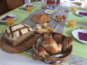 einen Tisch mit einem Korb Brot und anderen Lebensmitteln in der Unterkunft Chambres d'hotes Coeur de Sundgau in Leymen