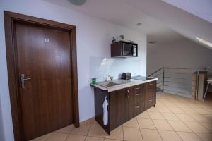 a kitchen with a sink and a wooden door at Willa Północna in Karwia