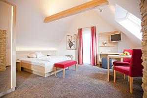 ein Schlafzimmer mit einem Bett und zwei roten Stühlen in der Unterkunft Hotel Krone OHG in Gerlingen