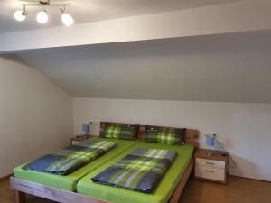 una camera con un letto verde di Schweizer´s Ferienwohnung ad Achberg