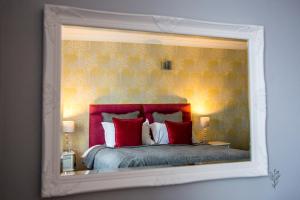 a bedroom with a large bed with red pillows at Cricklade House Hotel, Sure Hotel Collection by Best Western in Cricklade