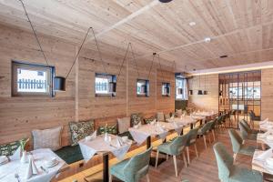 a restaurant with wooden walls and tables and chairs at Urbanhof in Sölden