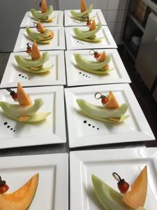 eine Reihe weißer Teller mit Früchten darauf in der Unterkunft Hotel Stüa Granda in Soglio