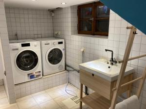 a laundry room with a washing machine and a sink at Ferienhaus Valentin in Oberammergau in Oberammergau