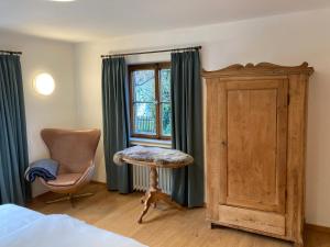 a bedroom with a bed and a chair and a window at Ferienhaus Valentin in Oberammergau in Oberammergau