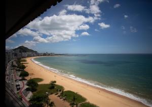 Elle offre une vue sur la plage et l'océan. dans l'établissement Suite Praia da Costa Confort, à Vila Velha