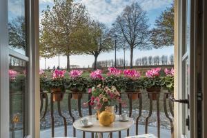 une fenêtre avec une table et des fleurs sur un balcon dans l'établissement Le Scuderie RIBOT Private Parking on Site, à Lucques