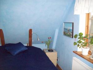 Dormitorio azul con cama y ventana en Carlssons på Vik en Simrishamn