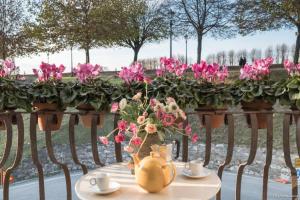 une table avec un vase de fleurs roses sur une clôture dans l'établissement Le Scuderie RIBOT Private Parking on Site, à Lucques
