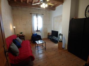 ein Wohnzimmer mit einem roten Sofa und einem Fenster in der Unterkunft Charmante maison arlésienne à l'ombre des Arènes, de 2 à 5p in Arles