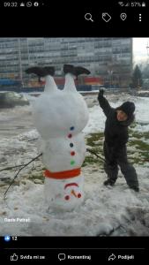 a woman is standing next to a snowman at Apartman Anika in Moravice