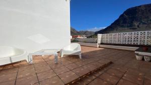 a patio with two white chairs and a table at Casa Camilo I in Valle Gran Rey