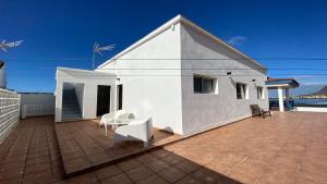 a white house with white chairs on a patio at Casa Camilo I in Valle Gran Rey