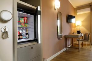 a refrigerator in a room with a table and a desk at Mercury Rooms in Cagliari