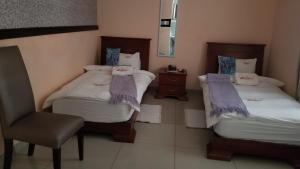 a room with two beds and a chair in it at A-Z Boutique Guesthouse in Windhoek
