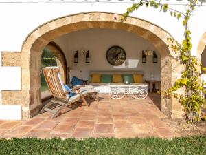 an archway with a table and chairs on a patio at Holiday Home El Torrero by Interhome in Benitachell