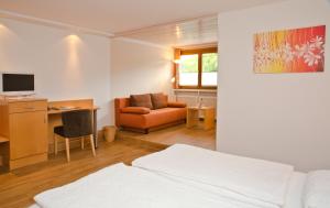 een slaapkamer met een bed, een bureau en een stoel bij Gartenhotel Feldeck in Lauchringen