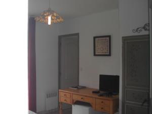 le patio في تورتور: غرفة بها مكتب مع تلفزيون ومرآة
