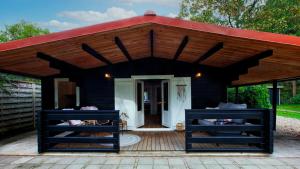 a black house with a red roof at So Rosie in Babberich