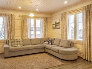 a living room with a couch and two windows at Holiday Home Villa sofia by Interhome in Vuokatti