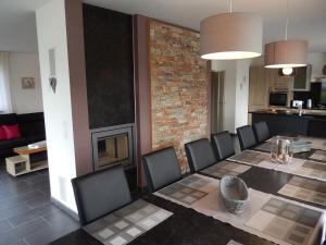 a dining room with a table and chairs and a fireplace at Gîte du Moulin - Rose in Trois-Ponts