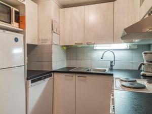 una cocina con armarios blancos y fregadero en Holiday Home Nurmennunnu by Interhome en Levi
