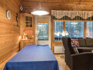 a dining room with a blue table and a couch at Holiday Home Nurmennunnu by Interhome in Levi