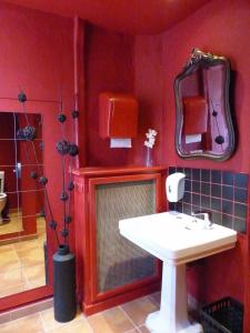baño rojo con lavabo y ducha en Hôtel de Provence en Brignoles