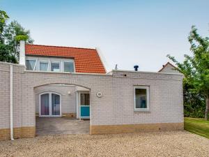 a white brick house with a large garage at Holiday Home Citta Romana-1 by Interhome in Hellevoetsluis