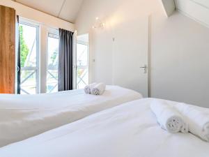 2 camas blancas en una habitación con ventana en Holiday Home Citta Romana-1 by Interhome, en Hellevoetsluis