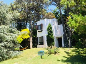 a white house in the middle of a yard at Cabañas MARE PARADISO in Costa del Este
