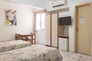 een kamer met 2 bedden, een keuken en een tafel bij OYO Real Palace Hotel, Teresina in Teresina