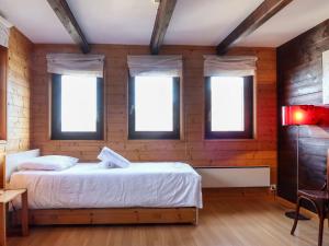 - une chambre avec un lit et trois fenêtres dans l'établissement Holiday Home La Place by Interhome, à Nendaz