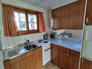 a small kitchen with a sink and a stove at Apartment Bärnermutz # 1 by Interhome in Lenk