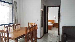 a dining room with a table and chairs and a bedroom at Residencial Chanel in Balneário Camboriú