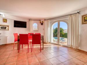 Balcon del MarにあるHoliday Home Uschi by Interhomeのダイニングルーム(赤い椅子、テーブル、窓付)