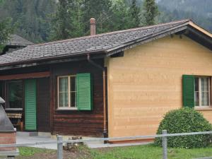 a small house with green shutters on it at Apartment Andrea by Interhome in Lenk