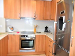 埃斯塔蒂特的住宿－Apartment La Platja by Interhome，厨房配有木制橱柜和不锈钢冰箱。