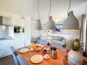 a kitchen and dining room with a wooden table with food on it at Holiday Home Citta Romana-1 by Interhome in Hellevoetsluis