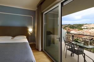 a bedroom with a bed and a balcony with a view at Mercury Rooms in Cagliari