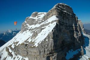 a kite is flying over a rocky mountain at Chalets du Vieux Frêne in Saint-Hilaire