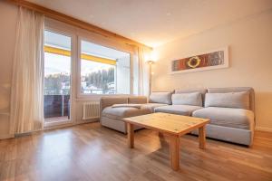 a living room with a couch and a table at Rothornblick 57 by Arosa Holiday in Arosa