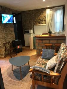 xalet l’avella 2 في Catí: غرفة معيشة مع أريكة وطاولة ومطبخ