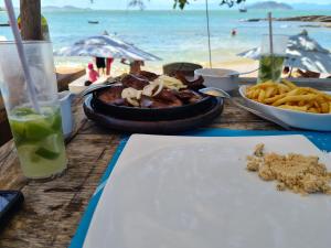 a table with a plate of food on the beach at Aura House Búzios in Búzios +56 photos
