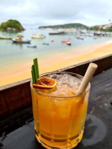 a drink on a table with a view of a harbor at Aura House Búzios in Búzios