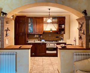 a kitchen with wooden cabinets and an archway at Relax, mare, natura e cavalli Giuliano di Roma in Giuliano di Roma