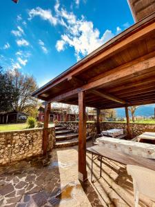 a wooden pavilion with a bench and a stone wall at Relax, mare, natura e cavalli Giuliano di Roma in Giuliano di Roma