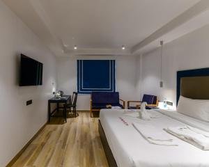 um quarto de hotel com uma cama grande e uma secretária em The Downton Hotel em Raipur